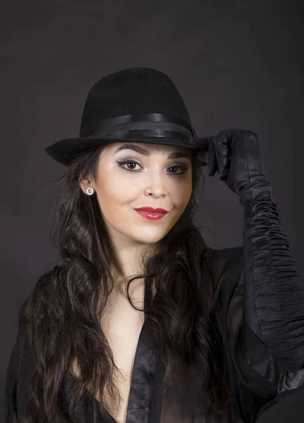 Hermosa joven en túnica negra, guantes negros y sombrero negro . — Foto de Stock