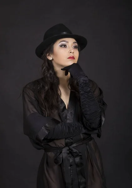 Vacker ung flicka i svart tunika, svarta handskar och svart hatt. — Stockfoto
