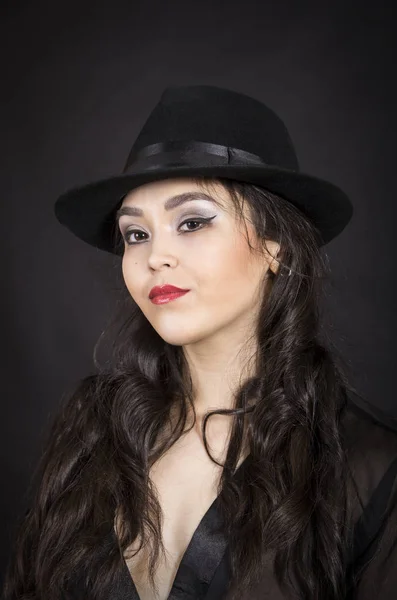 Hermosa joven en túnica negra, guantes negros y sombrero negro . — Foto de Stock