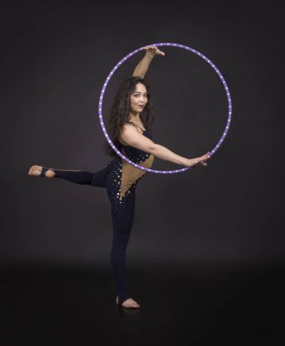 Hula Hoop kız ile jimnastik çalışmaları gerçekleştiren bir sirk sanatçısı.