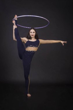 Hula Hoop kız ile jimnastik çalışmaları gerçekleştiren bir sirk sanatçısı.