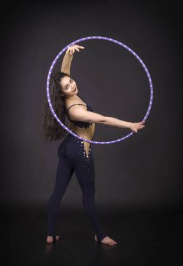 Hula Hoop kız ile jimnastik çalışmaları gerçekleştiren bir sirk sanatçısı.