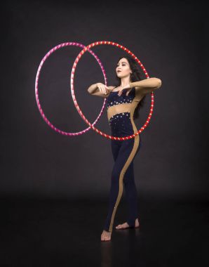 Hula Hoop kız ile jimnastik çalışmaları gerçekleştiren bir sirk sanatçısı.