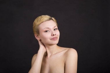 Koyu arka plan üzerinde sarışın kız portresi.