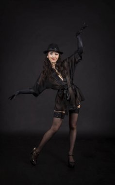 Siyah ceket, siyah eldiven ve siyah şapka dans güzel genç kız.