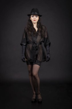 Siyah ceket, siyah eldiven ve siyah şapka dans güzel genç kız.