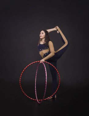 Hula Hoop kız ile jimnastik çalışmaları gerçekleştiren bir sirk sanatçısı.