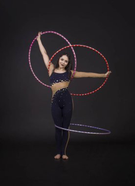 Hula Hoop kız ile jimnastik çalışmaları gerçekleştiren bir sirk sanatçısı.