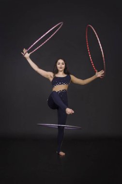 Hula Hoop kız ile jimnastik çalışmaları gerçekleştiren bir sirk sanatçısı.