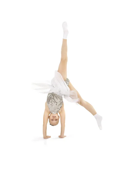一个穿着浅色舞台服的小女孩在白色背景下进行体操锻炼. — 图库照片