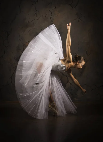 Chica delgada en un corsé blanco tutú bailando ballet. Estudio rodaje sobre un fondo oscuro, imágenes aisladas . — Foto de Stock