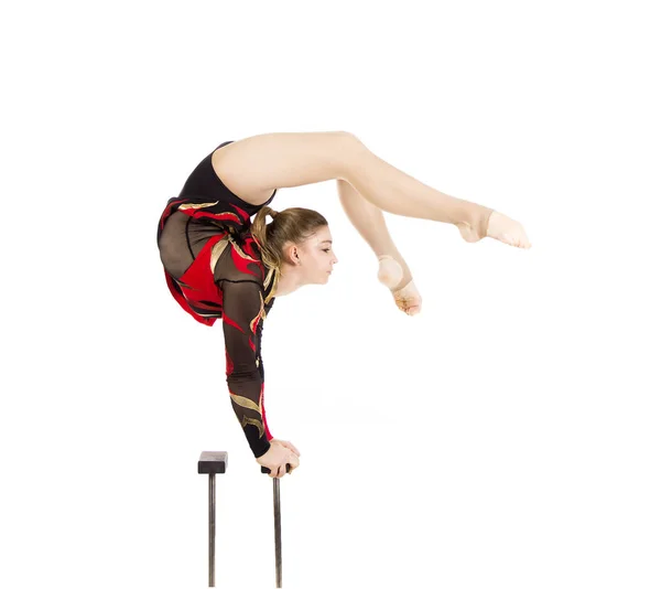 Krásný ekvilibrista v červeném a černém obleku, provádí cvičení na akrobatických tyčích. — Stock fotografie
