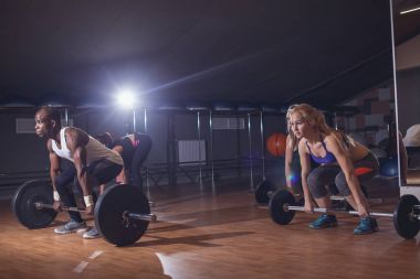 Spor salonunda ağır barbell ile Deadlift yapan insanlar. Yatay kapalı