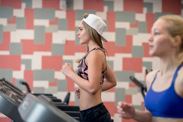 Mujeres en forma que corren en las cintas de correr en el gimnasio moderno —  Fotos de Stock