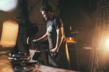 Demirci demircideki erimiş metali dövüyor..