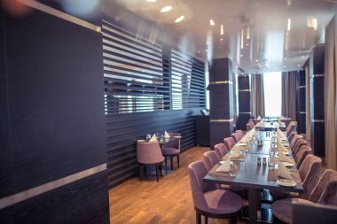 Bir Meksika restoranı ile çatı katı tarzında Half-lighted salonunda açık mutfak arka planda. Mutfak önünde çok renkli sandalyeler ve koltuklar ile ahşap tablolar vardır. Kanepeler var