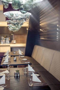 Bir Meksika restoranı ile çatı katı tarzında Half-lighted salonunda açık mutfak arka planda. Mutfak önünde çok renkli sandalyeler ve koltuklar ile ahşap tablolar vardır. Kanepeler var