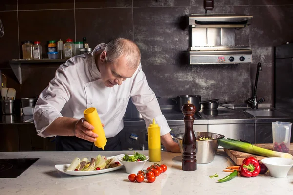 Chef-kok in hotel of restaurant keuken koken, hij is bezig met de saus voor het voedsel als meer saucier — Stockfoto