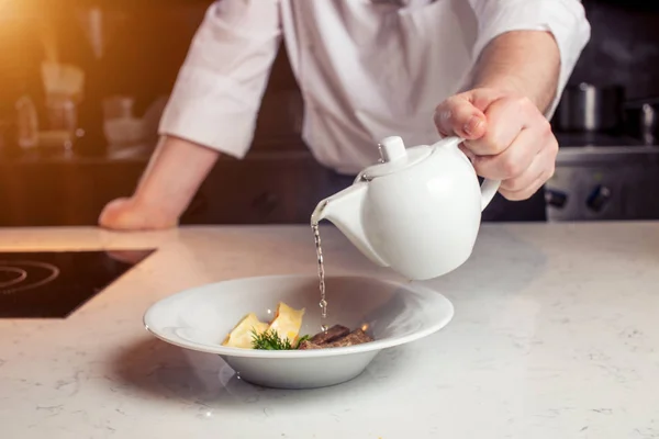 Chef - solo torso para ser visto - en un restaurante o cocina de hotel que está preparando la salsa — Foto de Stock