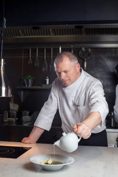 Chef in hotel or restaurant kitchen cooking, he is working on the sauce for the food as saucier — Stock Photo, Image