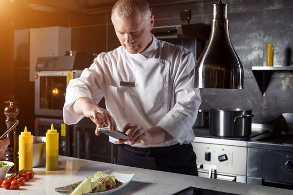 Chef-kok schieten van voedsel op smartphone — Stockfoto