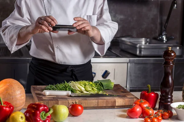 Şef ateş smartphone cep telefonu ile gıda — Stok fotoğraf