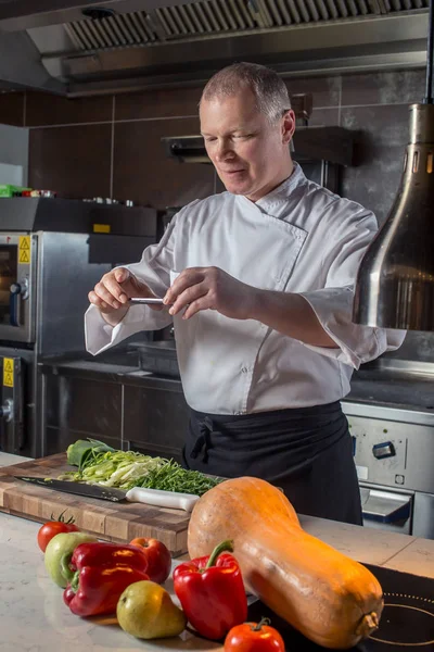 Chef sesión de comida en el teléfono inteligente — Foto de Stock