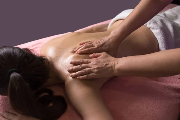 Massagista fazendo massagem na mulher de volta no salão de spa — Fotografia de Stock