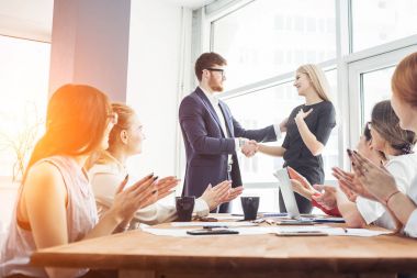 Gemiye hoş geldiniz! Onların arkadaşları ile ofisinde kanepede otururken gülümseme ile el sıkışan iki yakışıklı erkekler