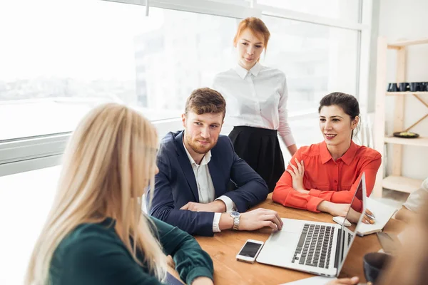 Başarılı takım lideri ve iş sahibi resmi olmayan iş toplantısına liderlik ediyor. Ön planda dizüstü bilgisayarda çalışan bir iş adamı. İş ve girişimcilik kavramı.