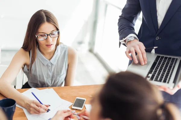 Mujer de negocios escribir en el papel y el ordenador portátil espectáculo masculino — Foto de Stock