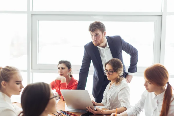 Schöner junger Mann, der am Computer arbeitet und in der Werkstatt lächelt — Stockfoto