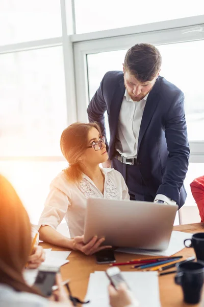 Mooie jonge man werken met behulp van computer en glimlachen terwijl je in werkplaats — Stockfoto