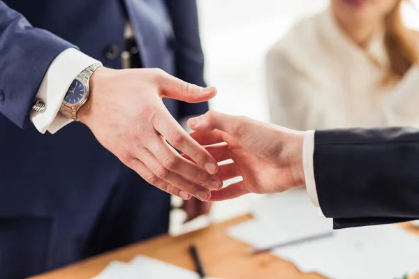 Ottimo affare. Primo piano di due uomini d'affari che si stringono la mano mentre sono seduti sul posto di lavoro — Foto Stock