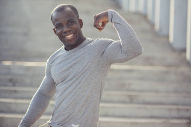 Güçlü atletik erkek Fitness onun pazı gösteren Model.