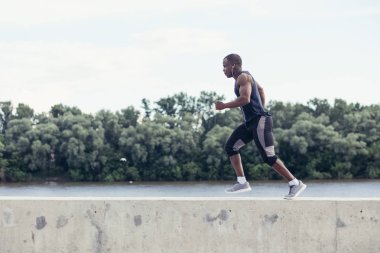 Çekici bir adam hızlı günbatımı ışık, siyah adam açık havada egzersiz yapmaya çalışan