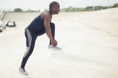 genç siyah erkek atlet ayakkabı bağı bağlama