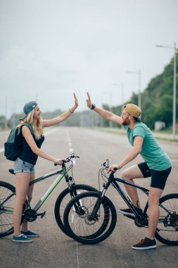 bisikletçi çift ayakta zirve yüksek çakmak güneşli bir günde uygun.