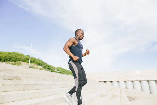 African young man athlete steps up with energy in bleachers — Stock Photo, Image