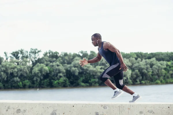Здоровий молодий спортсмен біжить по дорозі — стокове фото
