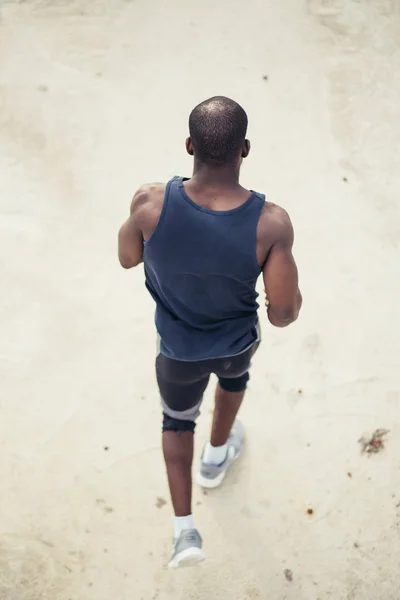 Rear view. African runner runs along the stairs — Stock Photo, Image