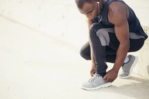 Jonge zwarte man runner koppelverkoop zijn schoenveters — Stockfoto