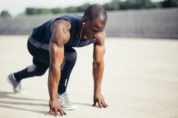 Athlete man in running start pose on the city street. Sport tight clothes. — Stock Photo, Image