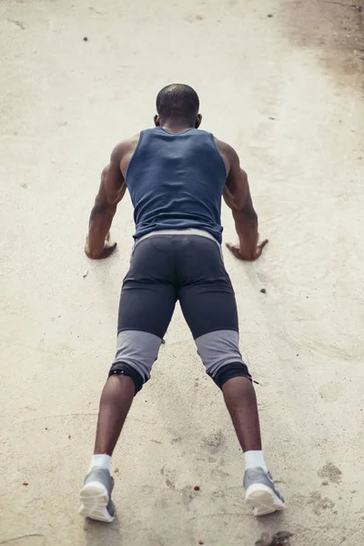 Porträt eines jungen Schwarzen, der Liegestütze am Strand macht — Stockfoto