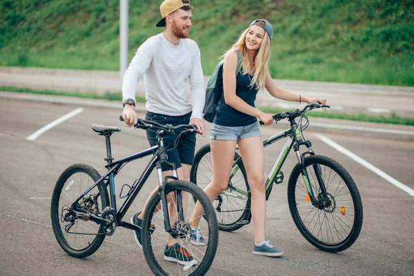행복 한 젊은 부 부가 손을 잡고 하 고 자전거를 타고 — 스톡 사진