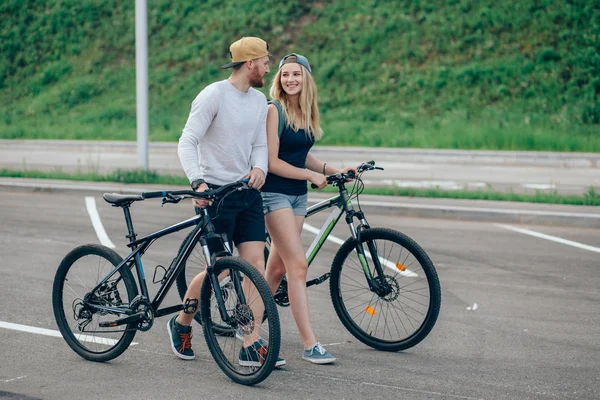 렌즈 플레어 멋진 일몰도 함께 자전거를 산책 하는 커플 — 스톡 사진