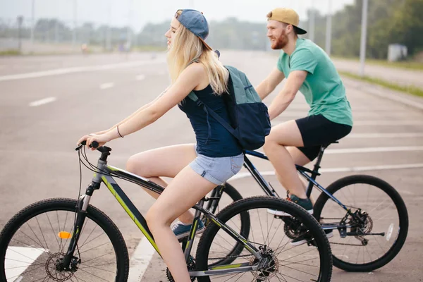 Vue latérale d'un homme et d'une femme d'âge moyen faisant du vélo — Photo