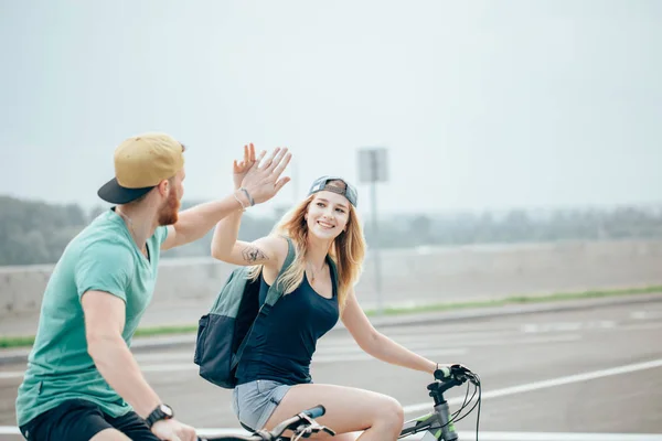 Feliz pareja de motociclistas dando cinco altos mientras monta en bicicleta en el campo — Foto de Stock