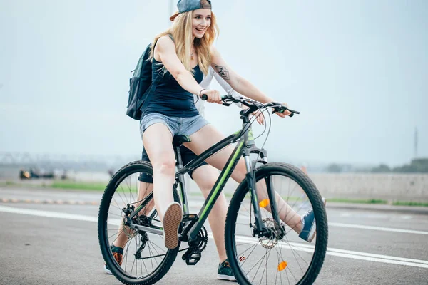 Mulher sexy com bicicleta em uma estrada de campo . — Fotografia de Stock