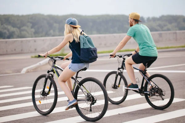 Visão traseira de um casal feliz andando de bicicleta segurando — Fotografia de Stock